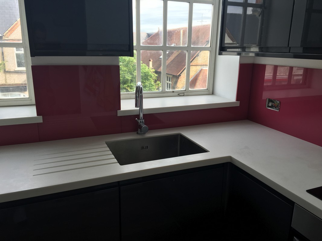 Deep plum coloured glass splashback in modern Neasden kitchen